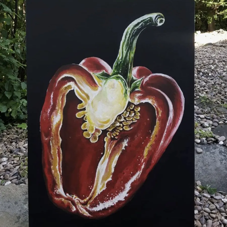 Pārgrieztas sarkanās paprikas glezna uz melna fona